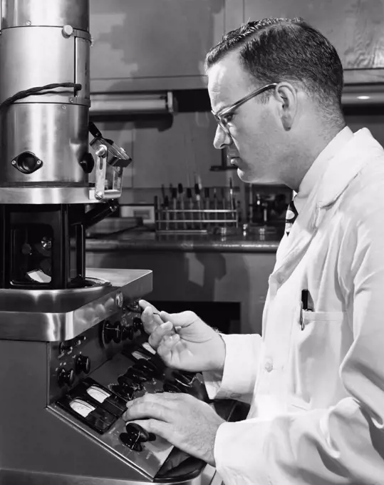 Side profile of a scientist working on an electron microscope