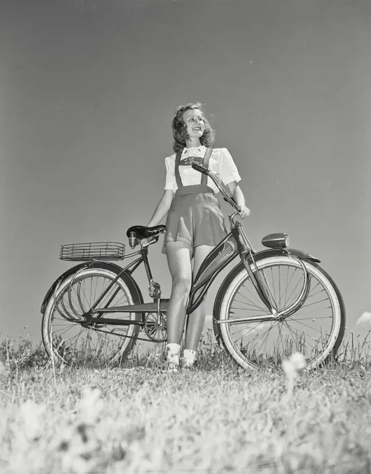 Low angle view of teenage girl with bicycle