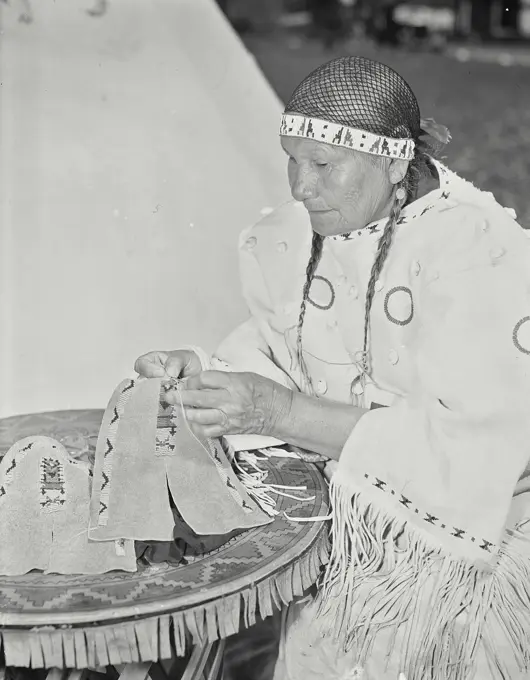 Vintage photograph. Native American woman making fancy bead work