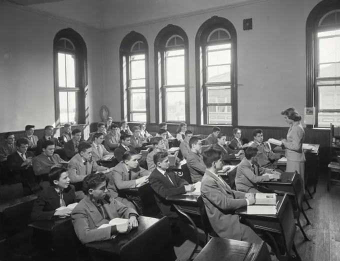 Vintage photograph. Female teacher teaching students in a classroom