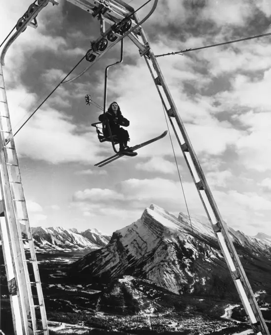 Low angle view of a woman sitting on a ski lift, Banff National Park, Alberta, Canada