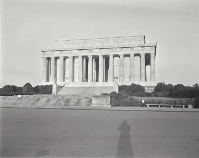 Vintage photograph. Sunrise scene, closed Lincoln Memorial, photographer's shadow in foreground.