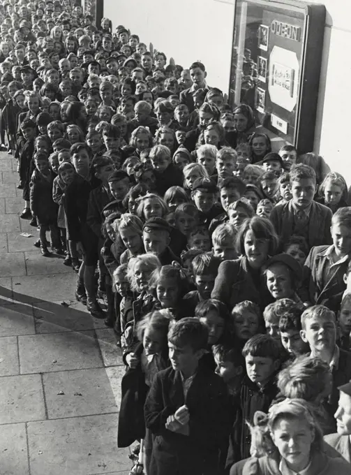 Vintage photograph. Crowd of children lined up in front of movie theater