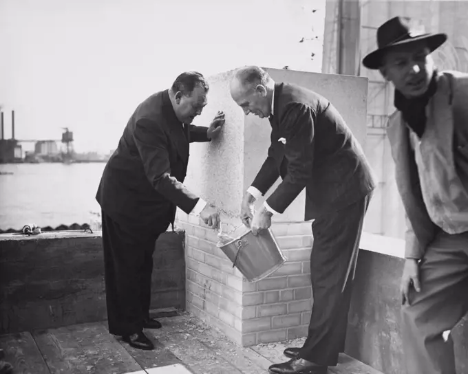 United Nations Secretary General Trygve Lie and Architect Wallace Harrison applying mortar to cornerstone of UN Headquarters building, New York City, USA October 1949