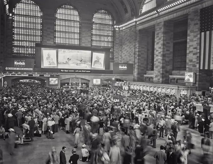 Vintage photograph. View looking towards Kodak Exhibit signs near entrance of a busy Grand Central Station.