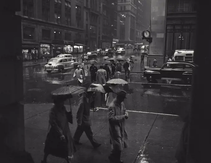 Vintage photograph. Looking south on Madison Avenue near 42nd Street, people with umbrellas on busy Manhattan street in the rain