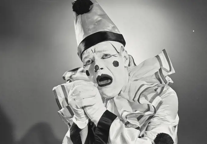 Vintage photograph. Portrait of clown in silly hat with shocked expression.