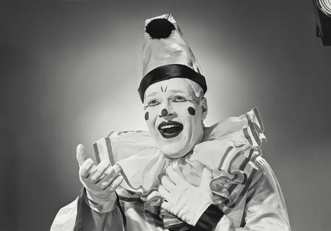 Vintage photograph. Portrait of clown in silly hat with excited expression.
