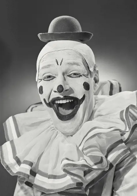 Vintage photograph. Portrait of clown wearing silly hat and smiling