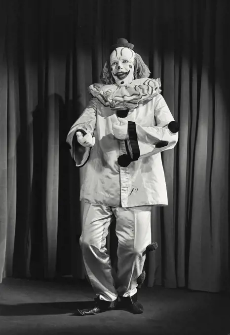 Vintage photograph. Portrait of clown wearing silly hat and dancing