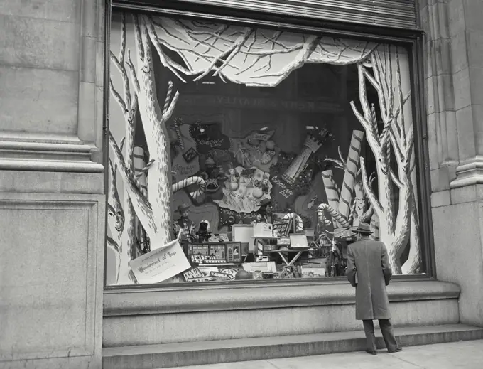 Vintage photograph. Man gazing through shop window.