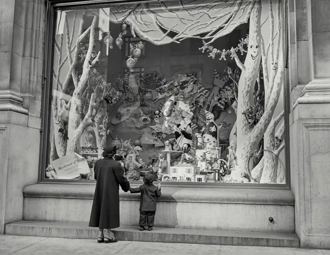 Vintage photograph. mother and son gazing through toy shop window