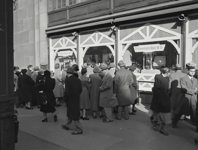 Vintage photograph. crowds out in front of shops gazing through window