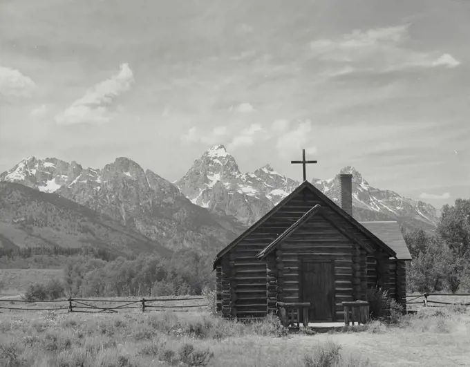 Vintage photograph. Famous Church of the Transfiguration near Moose, Wyoming with Teton Mountains in the background