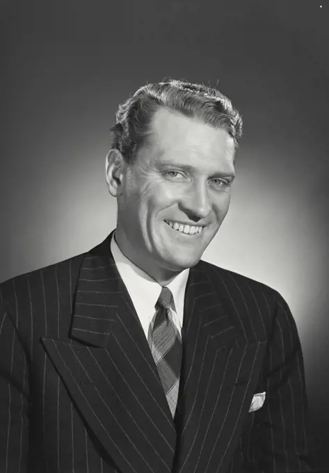 Vintage photograph. Handsome blonde man in pinstripe suit smiling