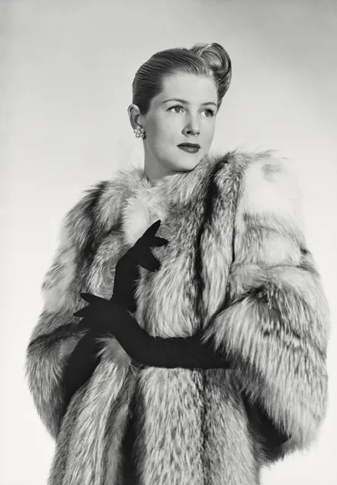 Vintage photograph. Woman in luxurious fur coat looking away