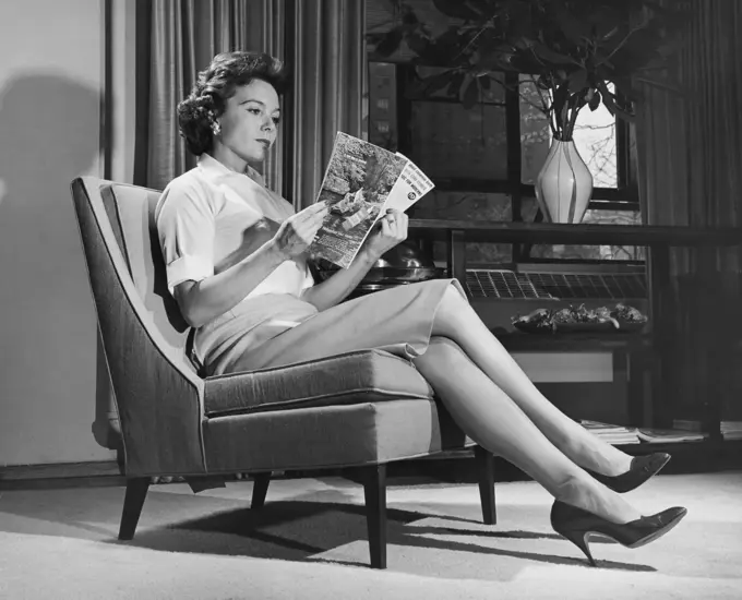 Side profile of a young woman reading a magazine