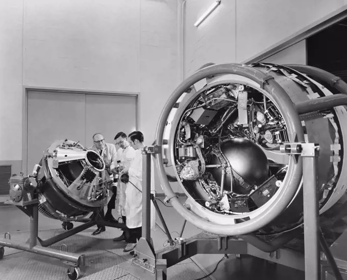 Three scientists working on satellites in a laboratory, GE Space Technology Labs, Valley Forge, Pennsylvania, USA
