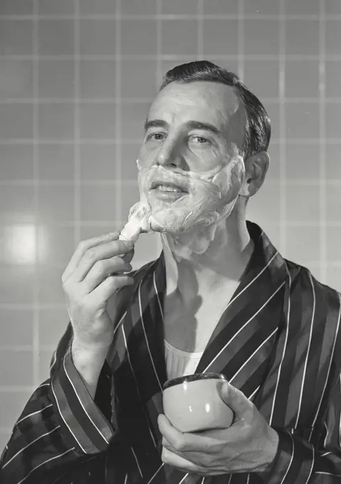 Vintage photograph. Man in robe applying shaving cream
