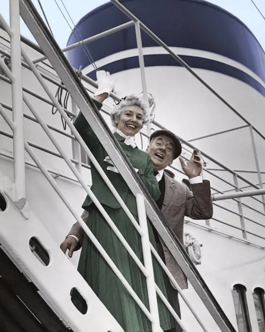 Portrait of senior couple waving from ship