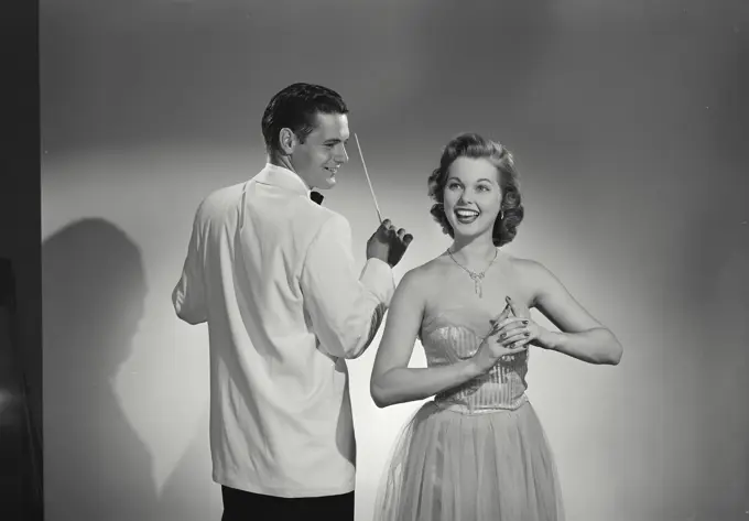 Young woman singing with a music conductor holding a conductor's baton behind her