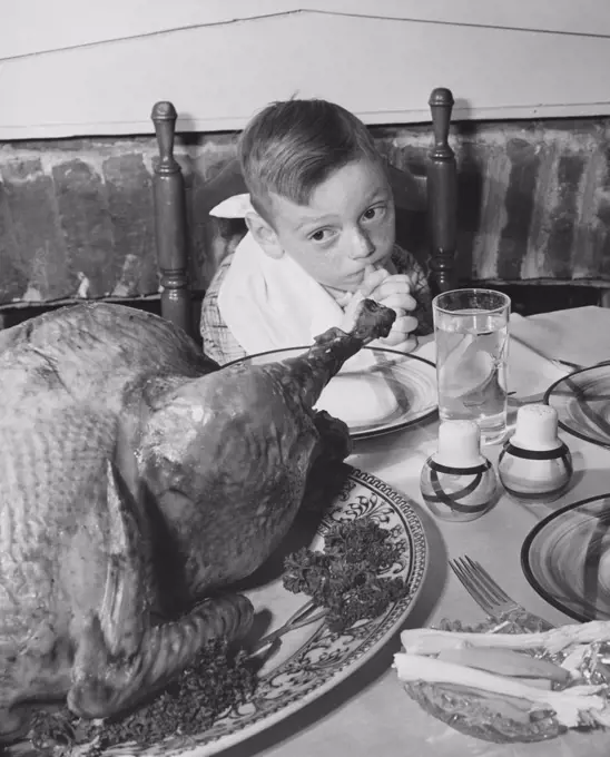 High angle view of a boy looking at a roasted turkey