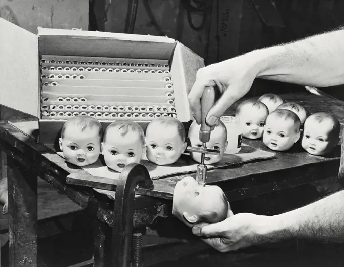 Vintage photograph. Doll manufacturing - cutting eyes on doll head