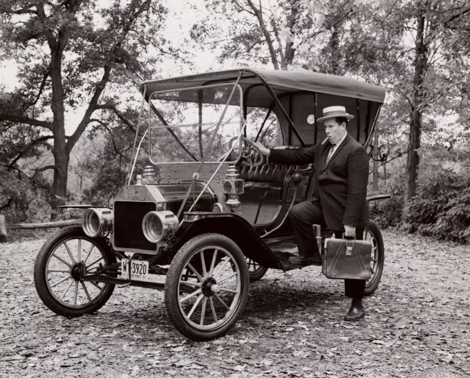 Businessman standing beside Ford Model T, 1910