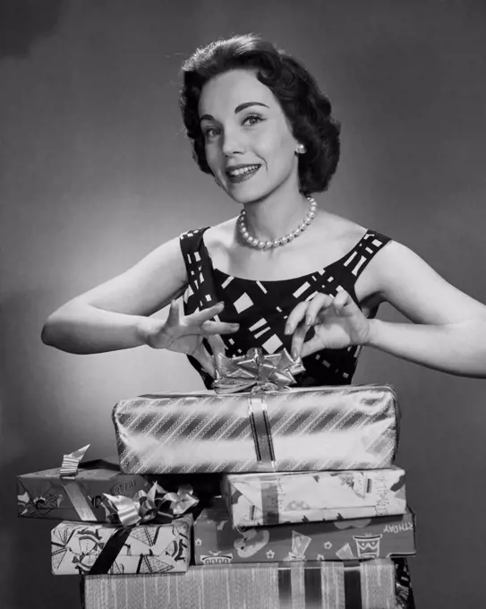 Portrait of a mid adult woman unwrapping Christmas presents and smiling