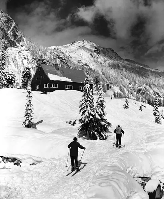 Rear view of two people skiing, Washington, USA