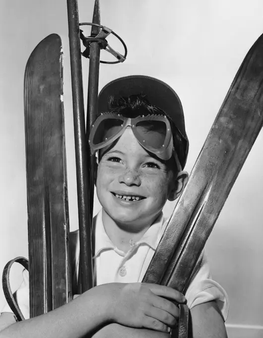 Boy holding skiing equipment