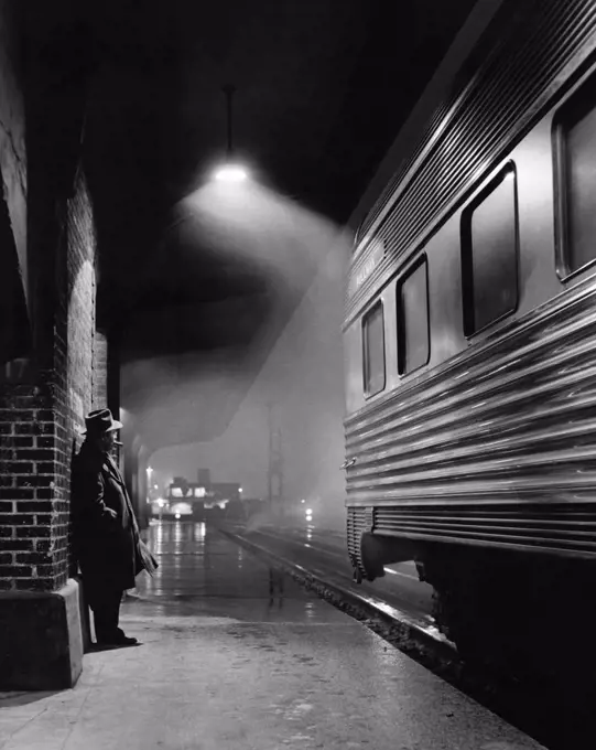 Man waiting for a train at a railway station