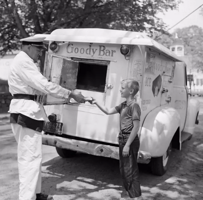 Boy buying ice cream from vendor