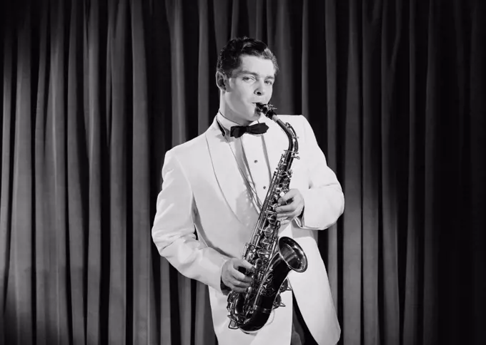 Portrait of young man playing saxophone on stage