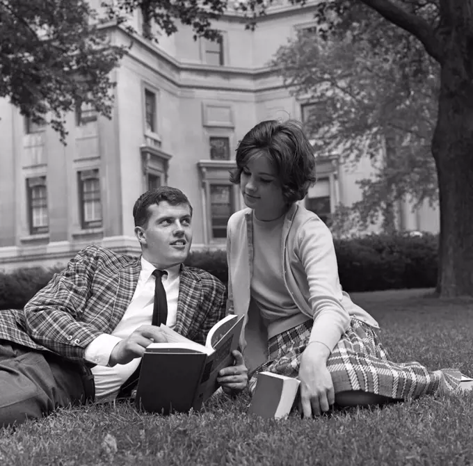 Young couple reading book on lawn