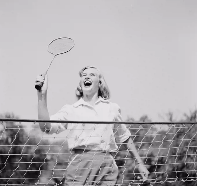 Close-up view of young woman playing badminton