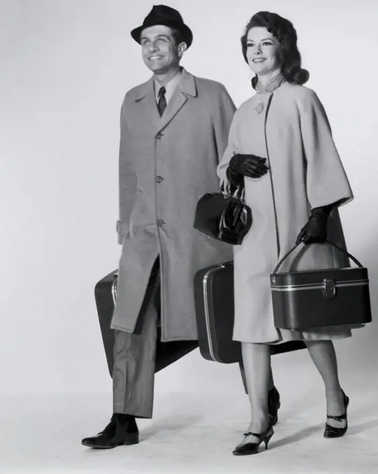 Mid adult couple walking with luggage