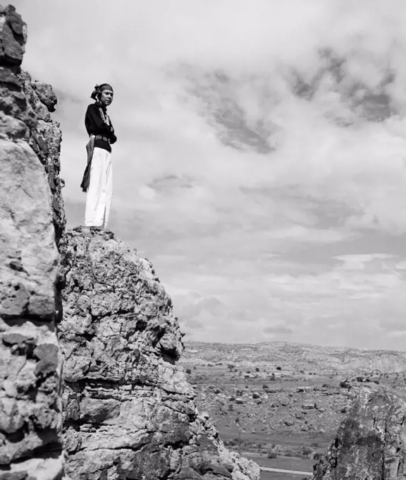Hopi man standing on a rock