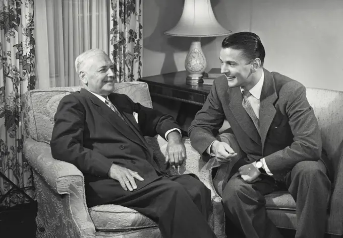 Young man and older man sitting together chatting