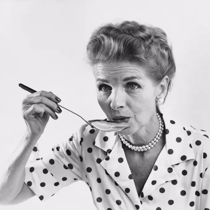 Senior woman tasting food with a spoon