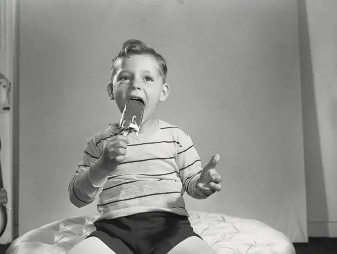 Vintage photograph. Close-up of a boy eating an ice cream