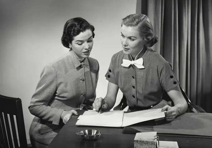 Close-up of two businesswomen discussing in an office