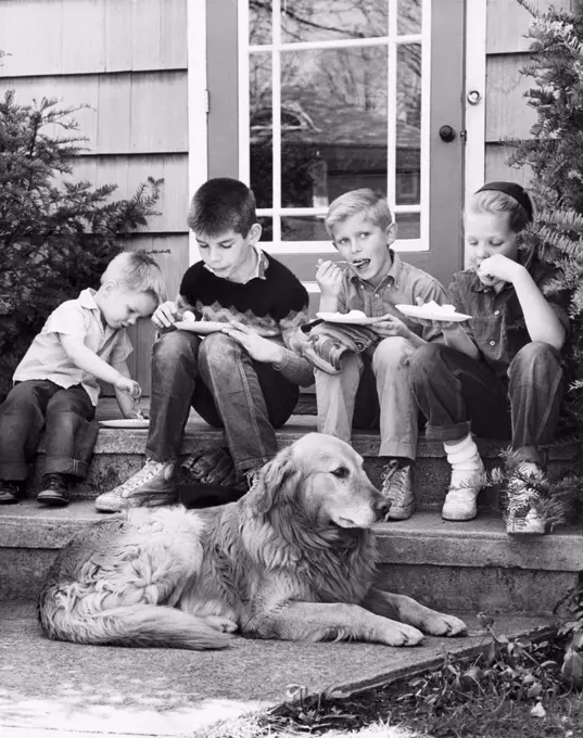 Four boys eating ice cream and a dog sitting in front of them