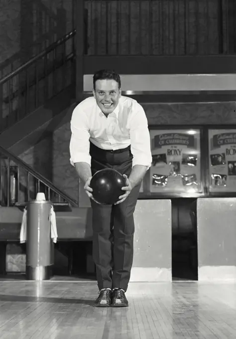 Vintage photograph. Young adult man about to bowl