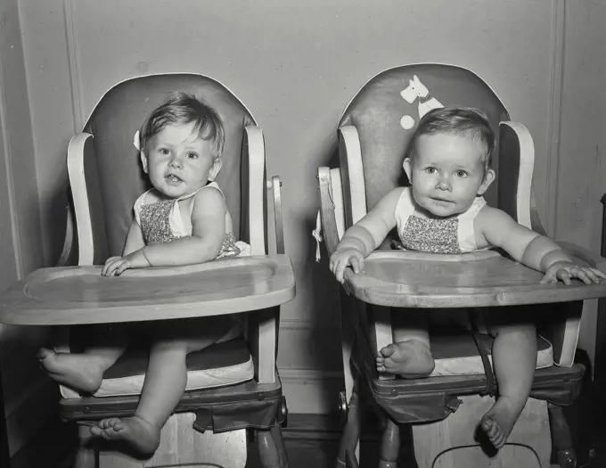 Vintage Photograph. Babies sitting next to each other in high chairs