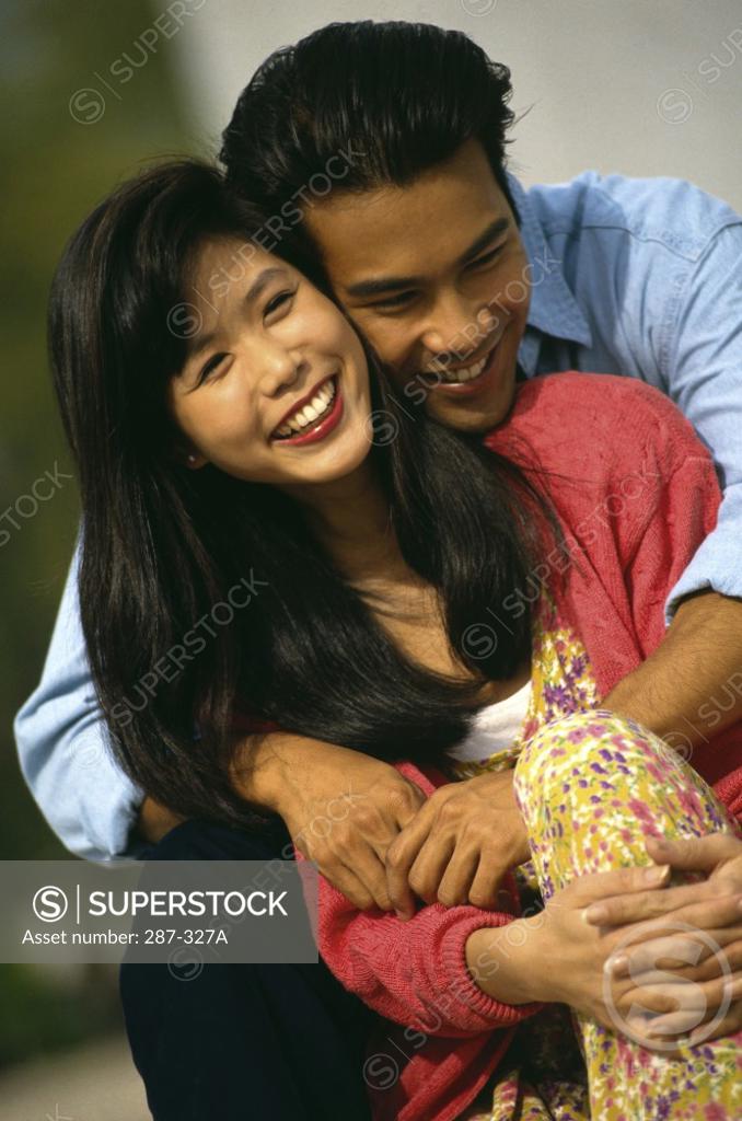 Stock Photo: 287-327A Close-up of a young man embracing a young woman from behind