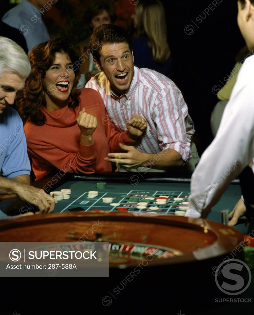 Stock Photo: 287-588A Mid adult couple laughing and looking excited after winning in a casino