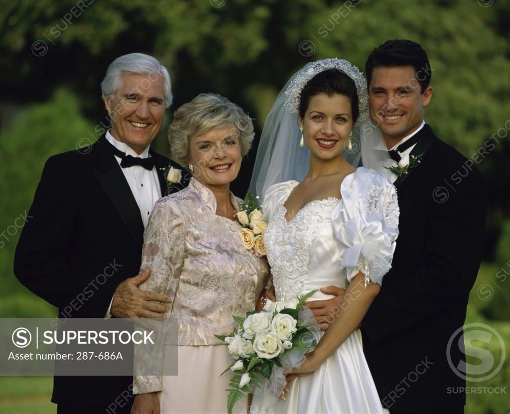 Stock Photo: 287-686A Newlywed couple standing with their parents and smiling