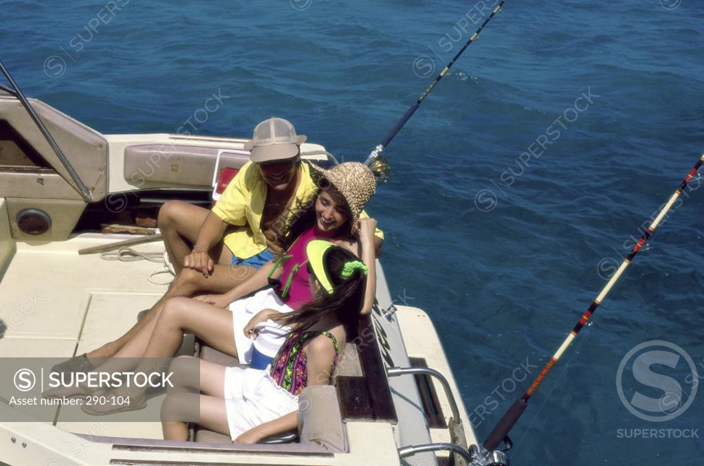 Stock Photo: 290-104 Young couple with their daughter sitting on a boat