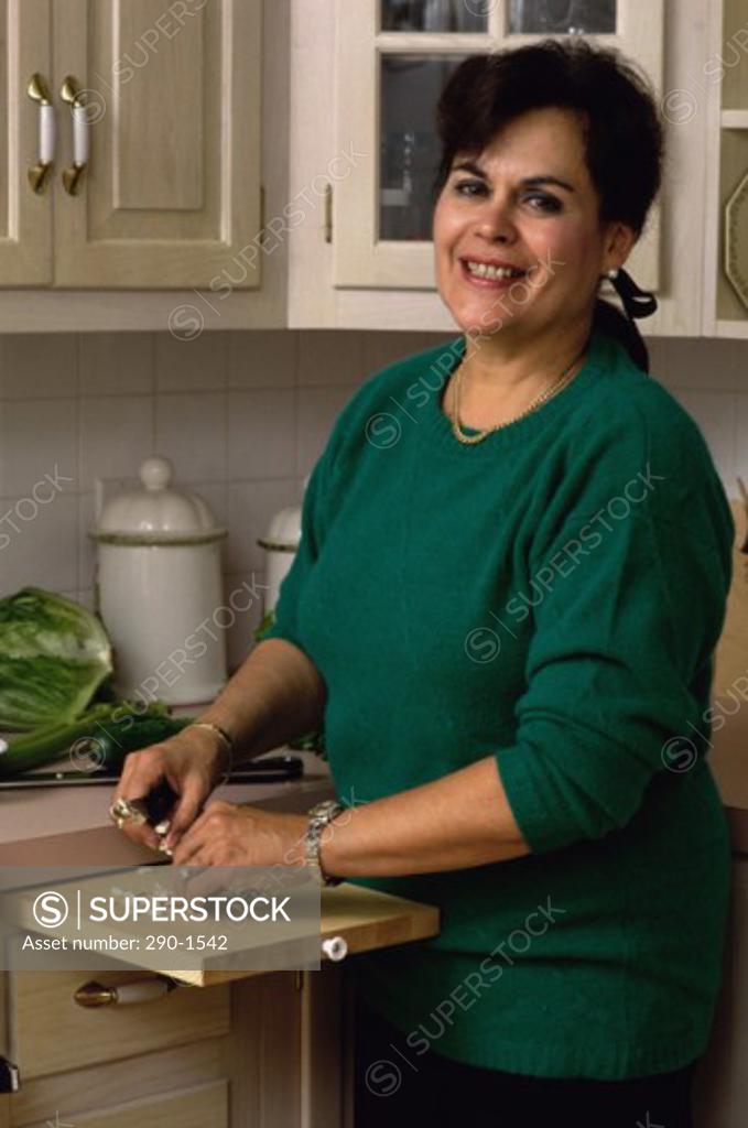 Stock Photo: 290-1542 Mature woman standing in a kitchen and smiling